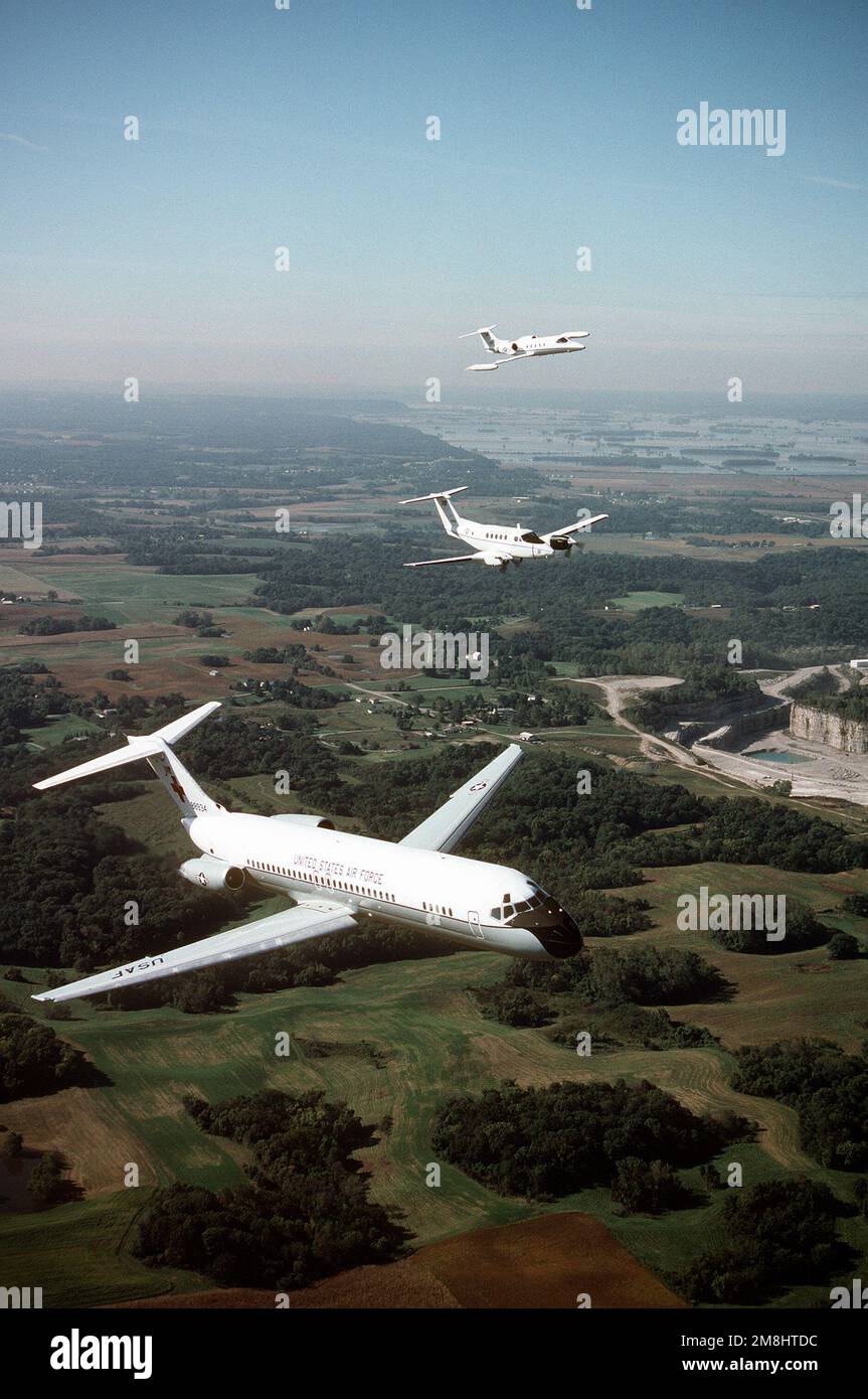 Une vue aérienne de trois quarts avant d'un avion C-9A Nightingale construit par McDonnell Douglas, avec un avion Beech construit C-12F et un Lear Jet construit C-21A volant de l'aile gauche du C-9. Tous les aéronefs proviennent de l'aile de transport aérien 375th, Air Mobility Command. Base: Scott Air Force base État: Illinois (il) pays: États-Unis d'Amérique (USA) Banque D'Images