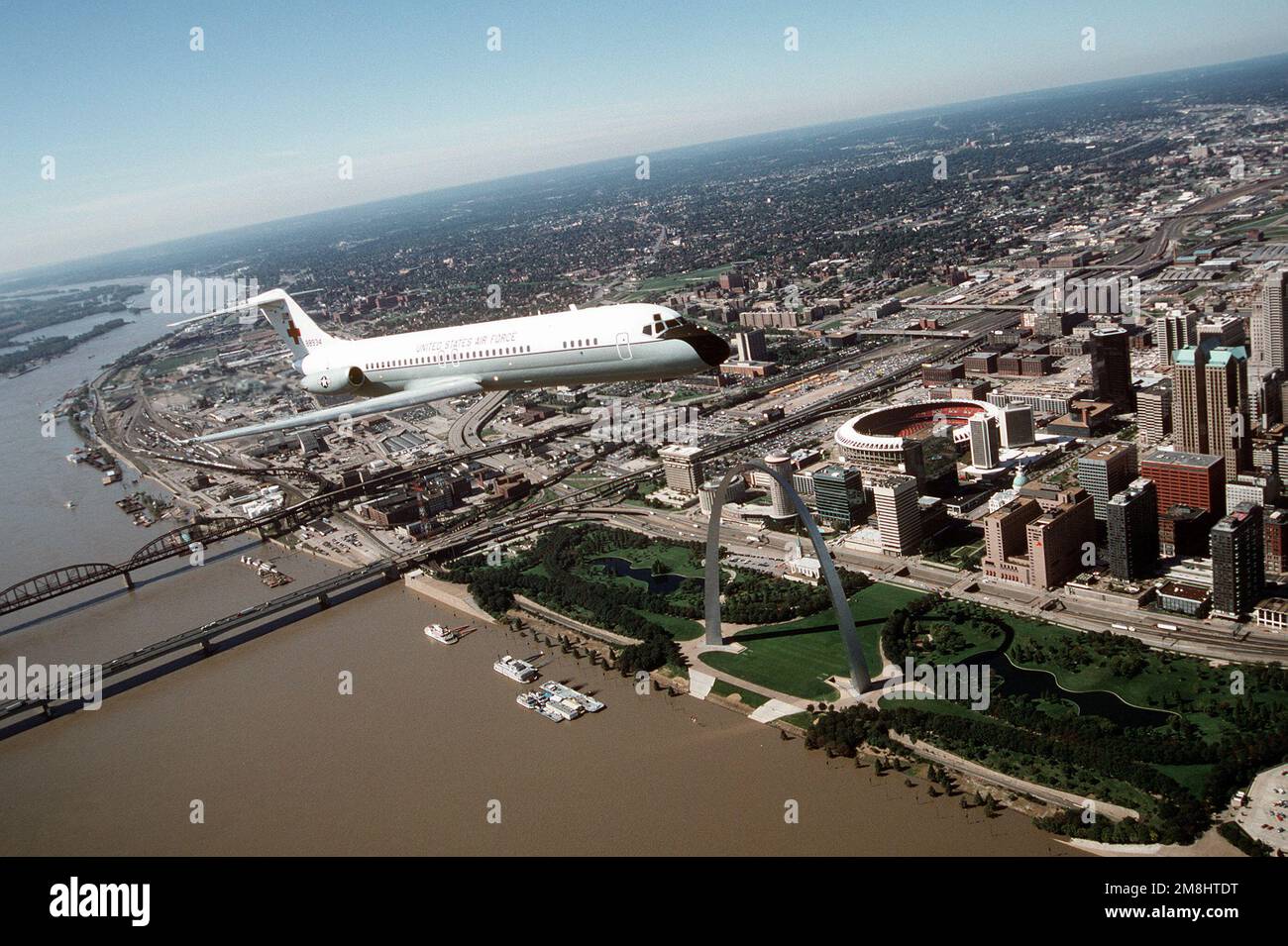 Vue aérienne de trois quarts d'un avion C-9A Nightingale construit par McDonnell Douglas au cours d'un vol au-dessus de la célèbre rue Louis Arch, sur les rives du Mississippi, et Busch Stadium. Le C-9A est affecté au Commandement de la mobilité aérienne de l'aile 375th du transport aérien. Base: Scott Air Force base État: Illinois (il) pays: États-Unis d'Amérique (USA) Banque D'Images