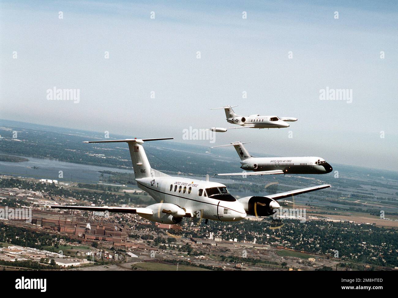 Vue aérienne de trois quarts avant d'un avion Beech construit en C-12F avec un Lear Jet construit en C-21A et un avion Nightingale construit en C-9A par McDonnell Douglas, volant de l'aile gauche du C-12F. Tous les aéronefs proviennent de l'aile de transport aérien 375th, Air Mobility Command. Base: Scott Air Force base État: Illinois (il) pays: États-Unis d'Amérique (USA) Banque D'Images