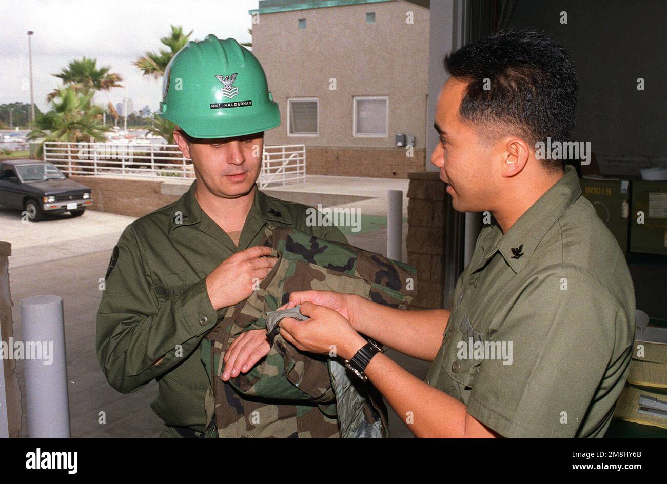 Navires Serviceman troisième classe (SH3) Mian demande à Radioman première classe (RM1) Halderman de signer pour son nouveau camouflage délivré uniformes qu'il a reçu à la place de l'ancien solide de travail vert jungle. Les deux Seabees sont affectés au bataillon de construction amphibie un (ACB-1) basé à la base amphibie Coronado. Base: San Diego État: Californie (CA) pays: Etats-Unis d'Amérique (USA) Banque D'Images
