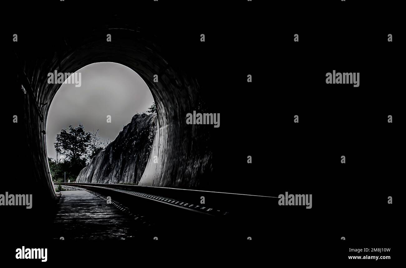 A l'intérieur du tunnel ferroviaire et des chemins de fer avec lumière naturelle à la fin. Lumière à la fin du tunnel, lumières et ombres, concept de réalisation de votre g Banque D'Images