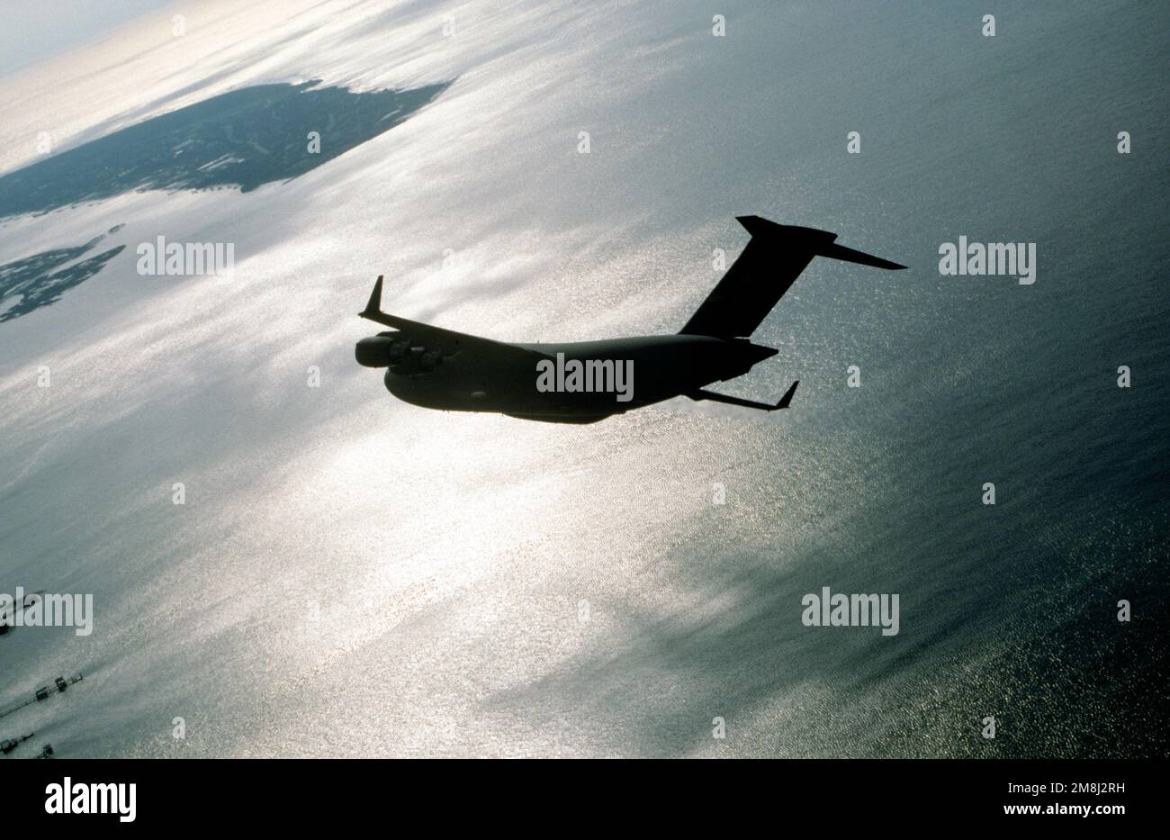 Air to air LEFT Side, Backlighted, View of a Air Mobility Command 437th Airlift Wing C-17 Globemaster III comme il tourne juste au-dessus de l'océan près de Charleston, Caroline du Sud. Date exacte prise de vue inconnue. Pays : inconnu Banque D'Images