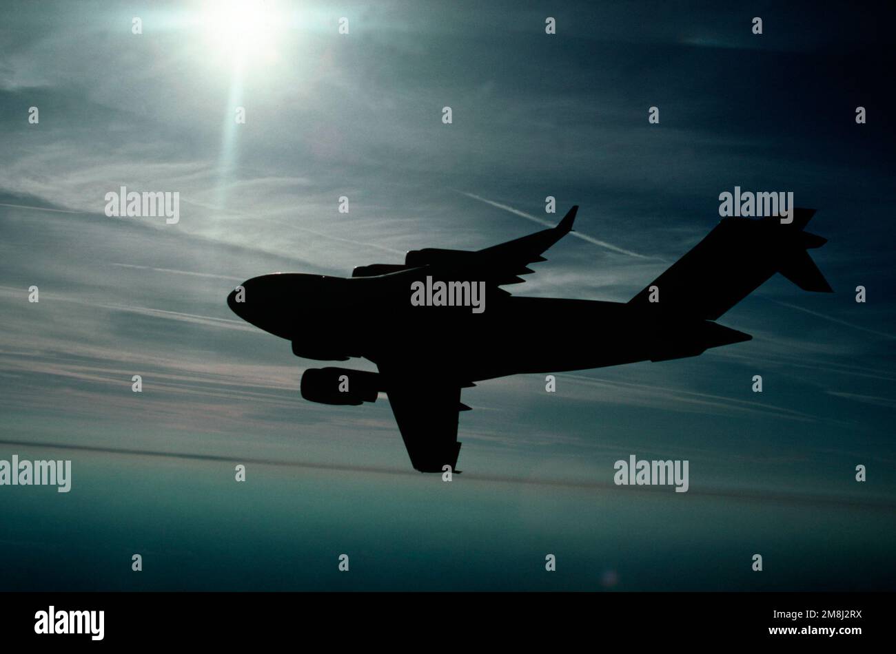 Air to air LEFT Side, Backlighted, View of a Air Mobility Command 437th Airlift Wing C-17 Globemaster III comme il tourne juste au-dessus de l'océan près de Charleston, Caroline du Sud. Date exacte prise de vue inconnue. Pays : inconnu Banque D'Images