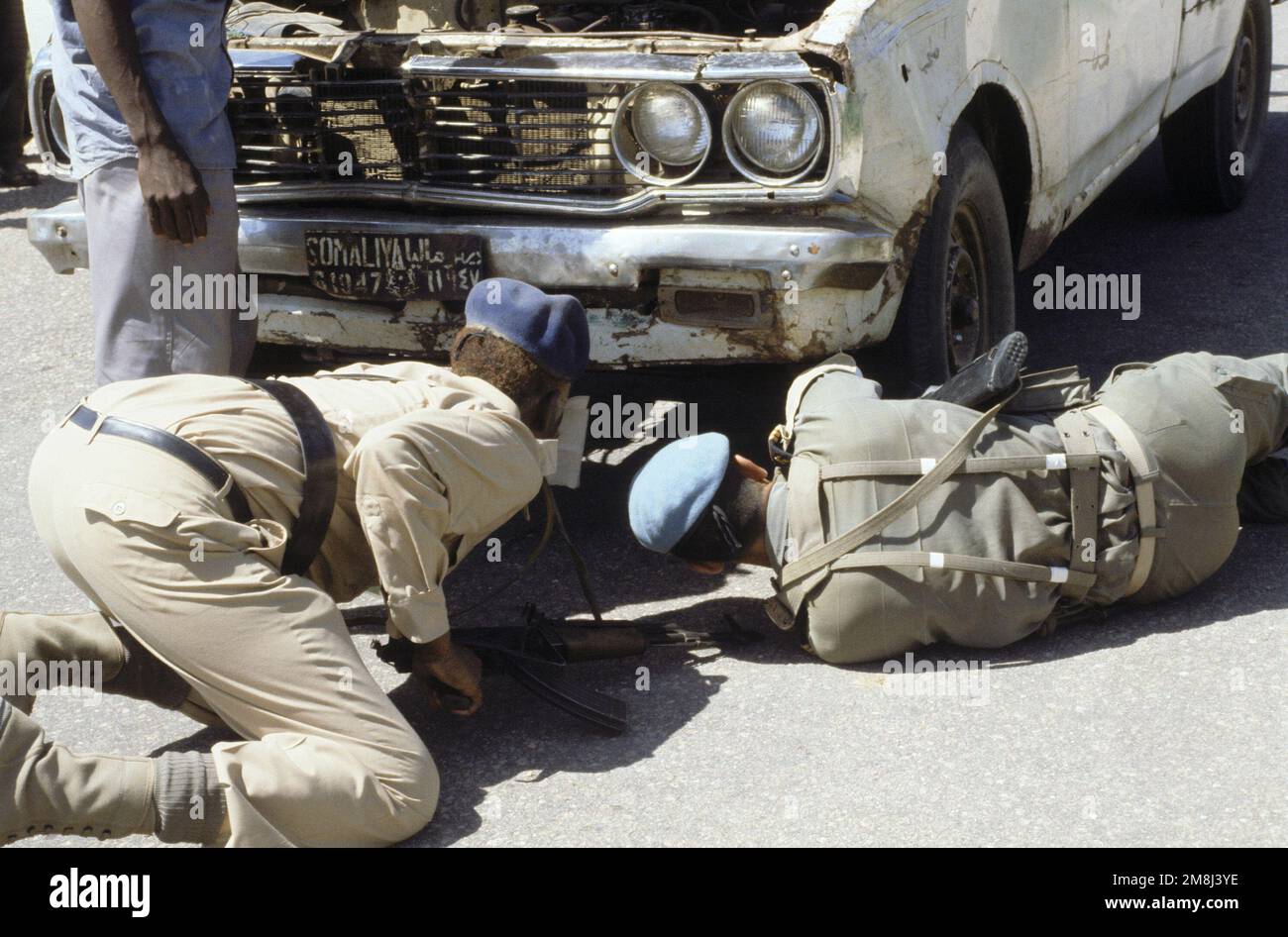 Un soldat français du détachement consultatif d'instruction militaire  (MMAD) du 5th Regiment International Army Overseas (RIAOM) forme un  policier somalien dans les techniques de recherche de véhicules. Les  Français assurent la formation