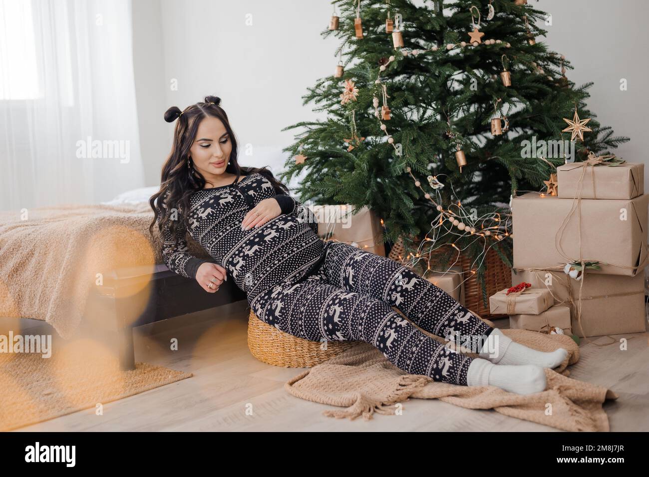 Belle femme enceinte en pyjama foncé, arbre de Noël en arrière-plan Photo  Stock - Alamy