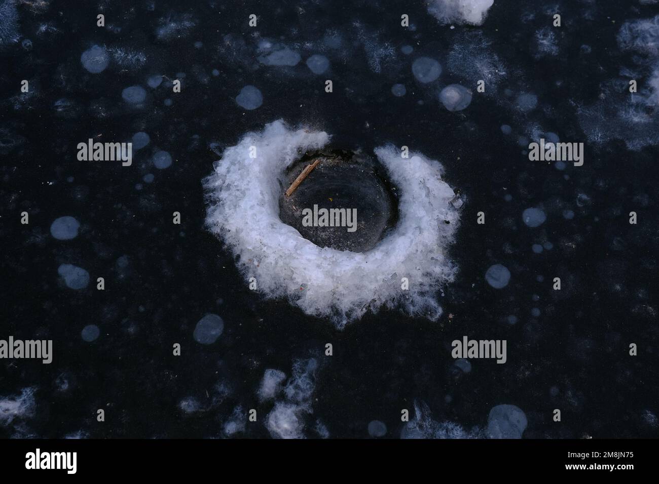 Le trou de pêche d'hiver dans la glace est gelé en raison de la température basse Banque D'Images