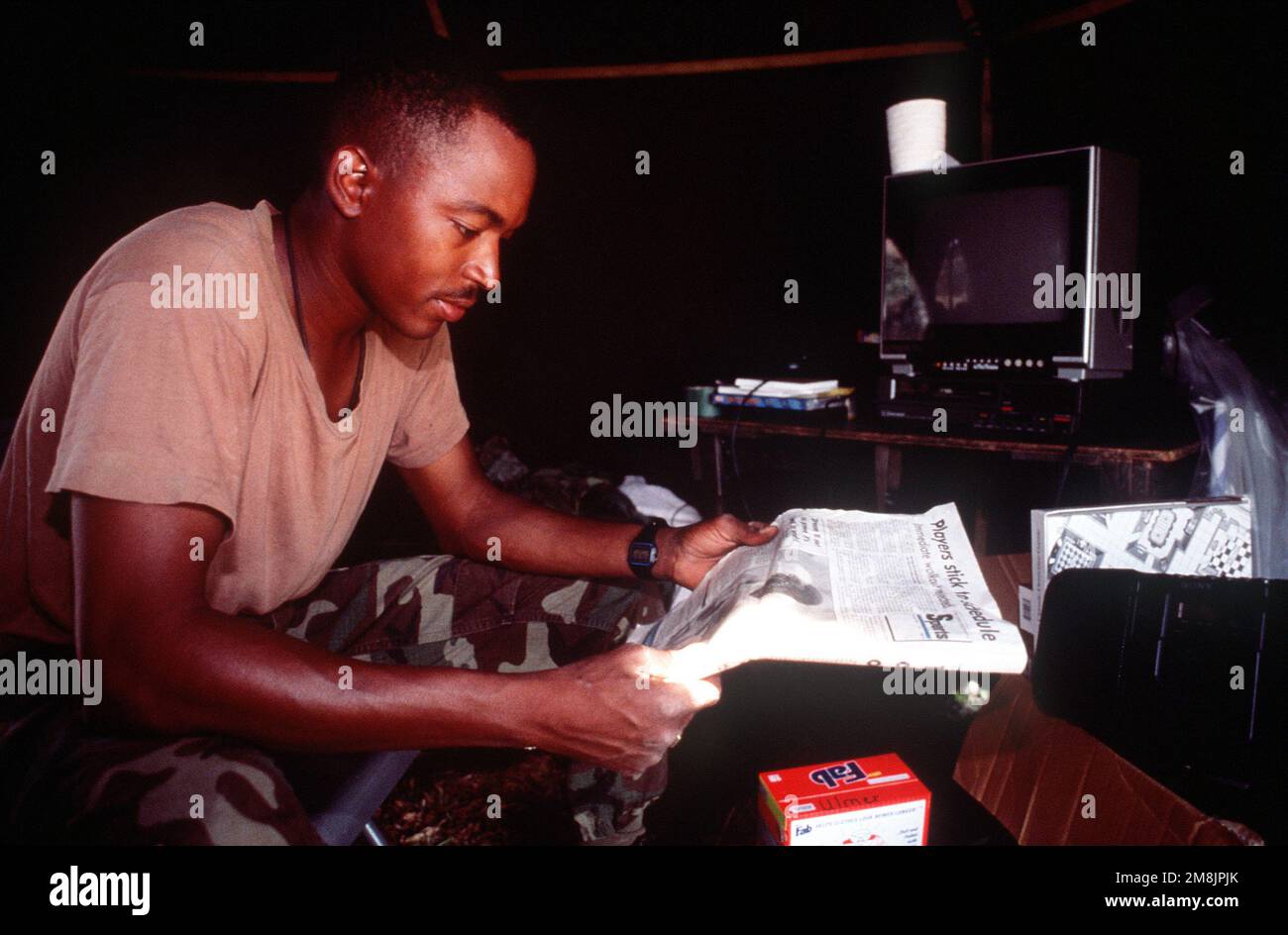 SGT. Arnold Platt, 72nd Bataillon des transmissions, armée américaine, Karlsruhe, Allemagne, lit un journal dans sa tente située à côté du terminal de l'aéroport. Sujet opération/série: RÉTABLIR LA BASE DE L'ESPOIR: Kigali pays: Rwanda (RWA) Banque D'Images