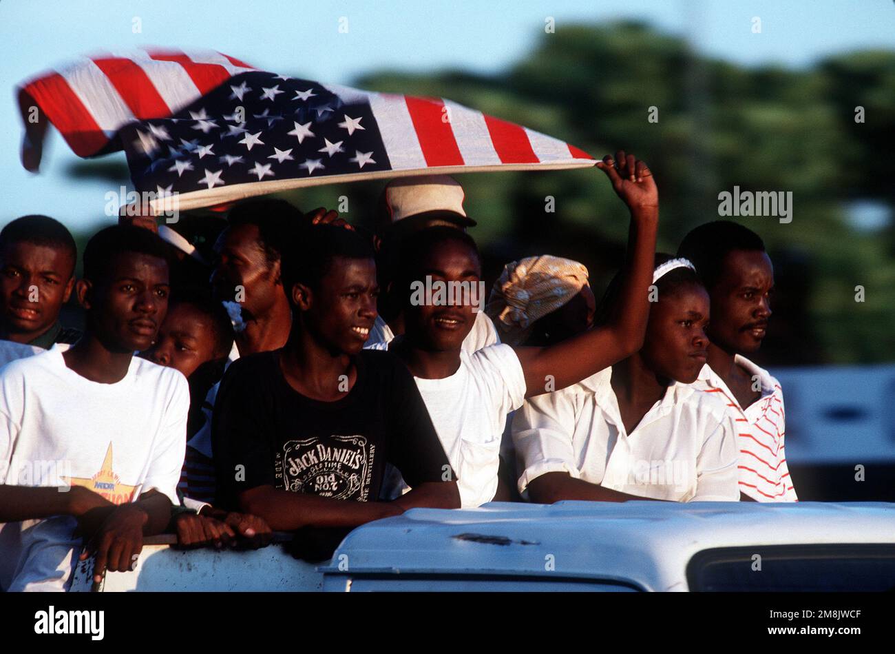 Les Haïtiens, agitant un drapeau des États-Unis, affichent des sentiments pro-américains à l'aéroport de Port-au-Prince. Date exacte prise de vue inconnue. Publié dans AIRMAN Magazine novembre 1994. Objet opération/série: DÉFENDRE LA DÉMOCRATIE base: Port-au-Prince pays: Haïti (HTI) Banque D'Images