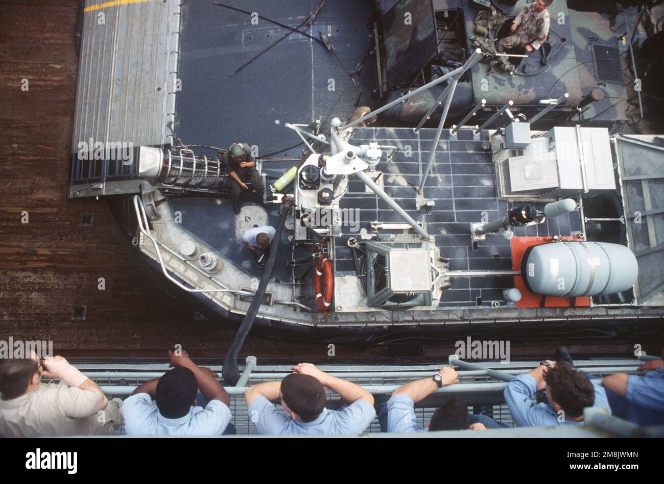 Des marins stationnés à bord de l'USS Portland regardent les membres de l'équipage de l'unité expéditionnaire maritime de 24th ravitailler les LCAC dans le pont du puits. Pays : inconnu Banque D'Images