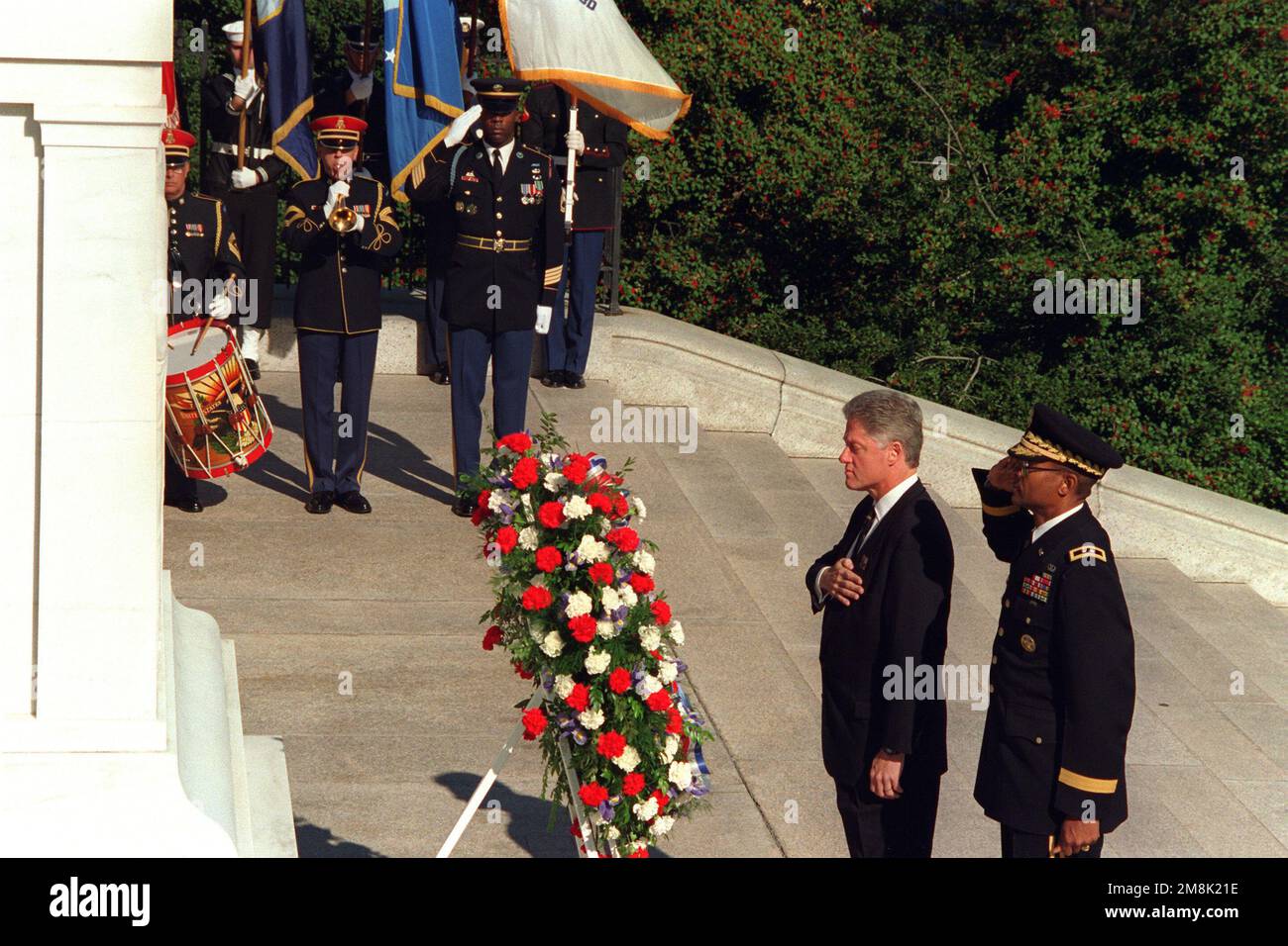 Le président William Jefferson Clinton et un américain Le major général de l'armée salue que les robinets sont joués par un membre des États-Unis Bande de l'armée, Pershings Own, après une présentation de la pose de la couronne lors d'une cérémonie de la fête des anciens combattants en début de matinée. Base: Cimetière national d'Arlington État: Virginie (va) pays: Etats-Unis d'Amérique (USA) Banque D'Images
