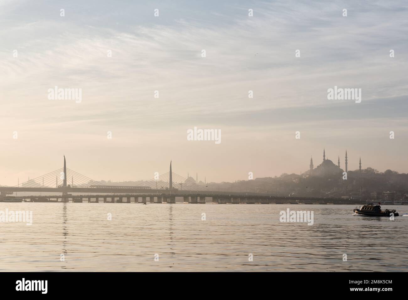 Istanbul, Turquie - janvier 2023 : vue au lever du soleil sur la mosquée Suleymaniye et le pont de métro de la Corne d'Or avec un voilier Banque D'Images