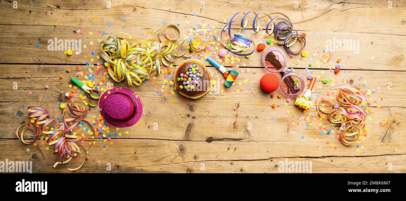 Beignets de Carnival d'Allemagne avec sucre glace sur une surface en bois clair avec confetti et banderoles sur elle - arrière-plan pour une fête de carnaval ou des fêtes Banque D'Images