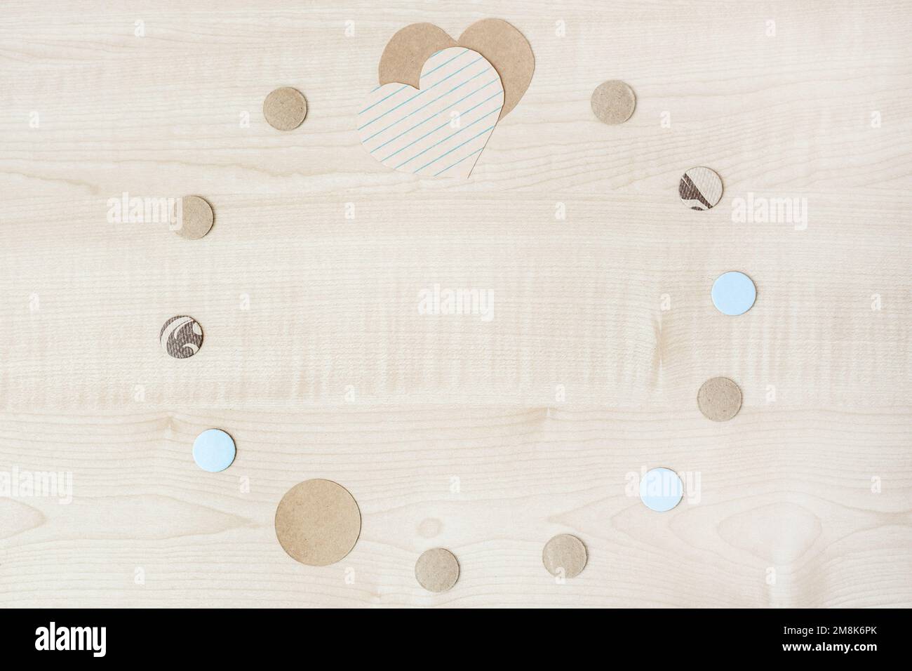 Cadre rond de coeurs en papier artisanal et de cercles sur fond en bois. Maquette de Saint-Valentin. Banque D'Images