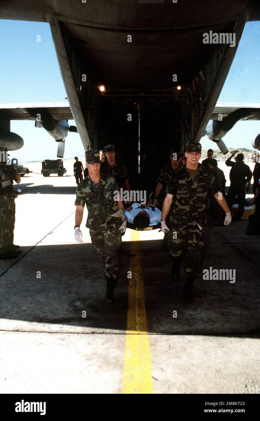 Le personnel militaire transporte un patient médical migrant cubain à partir d'un avion C-130 de l'US Air Force. Les migrants seront dépêché vers le côté venteux de la base pour être traités. Objet opération/série: BASE DE SIGNAL MARITIME: Guantanamo Bay pays: Cuba (CUB) Banque D'Images