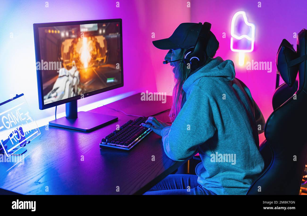 Gamer professionnel eSport féminin jouant dans un jeu vidéo de stratégie de compétition sur un Cyber Games Tournament à la maison. Parlez les uns aux autres dans des microphones. Banque D'Images