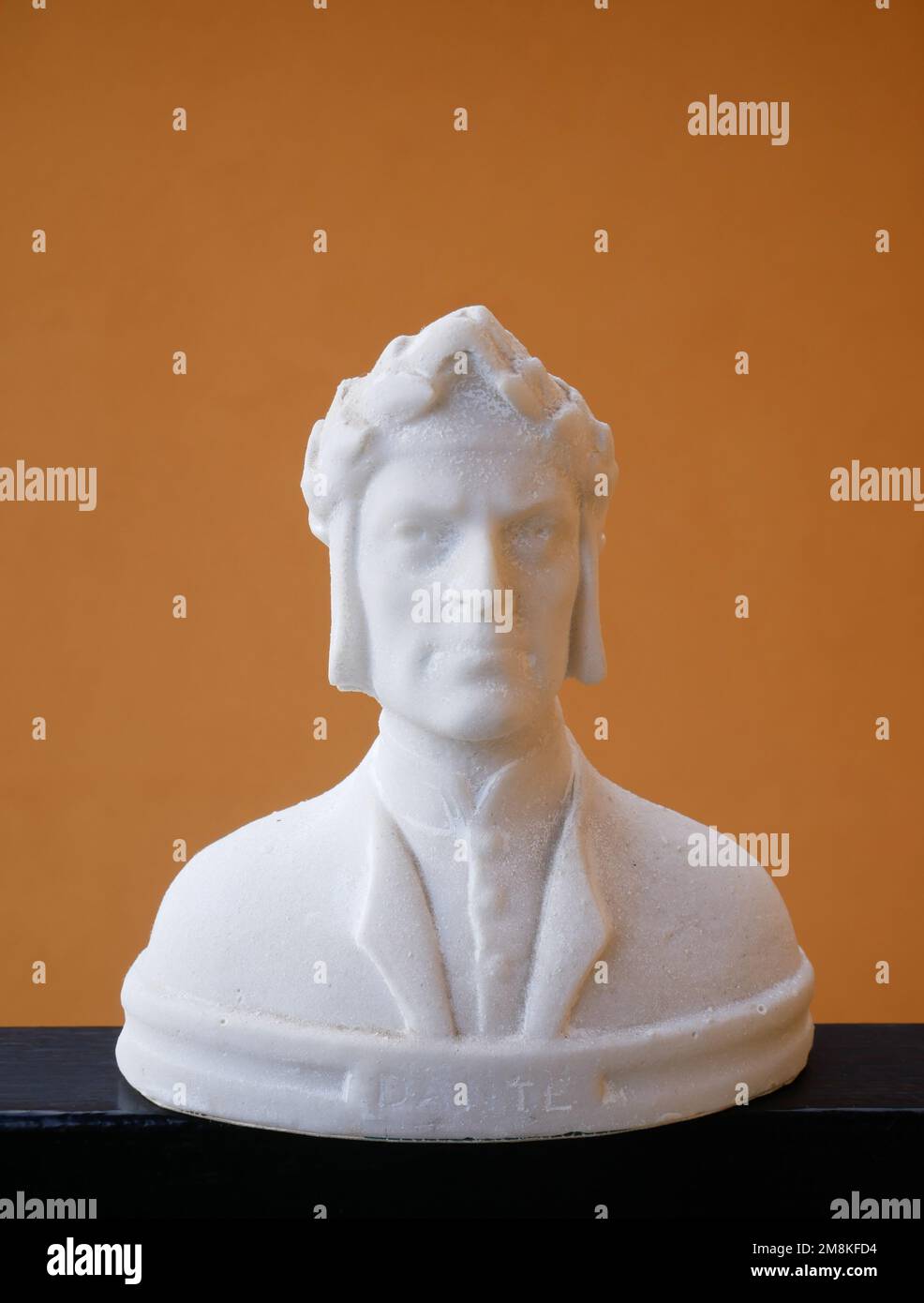 Reproduction à l'échelle du buste de Dante Alighieri sur fond orange, poète, écrivain et politicien italien. Banque D'Images