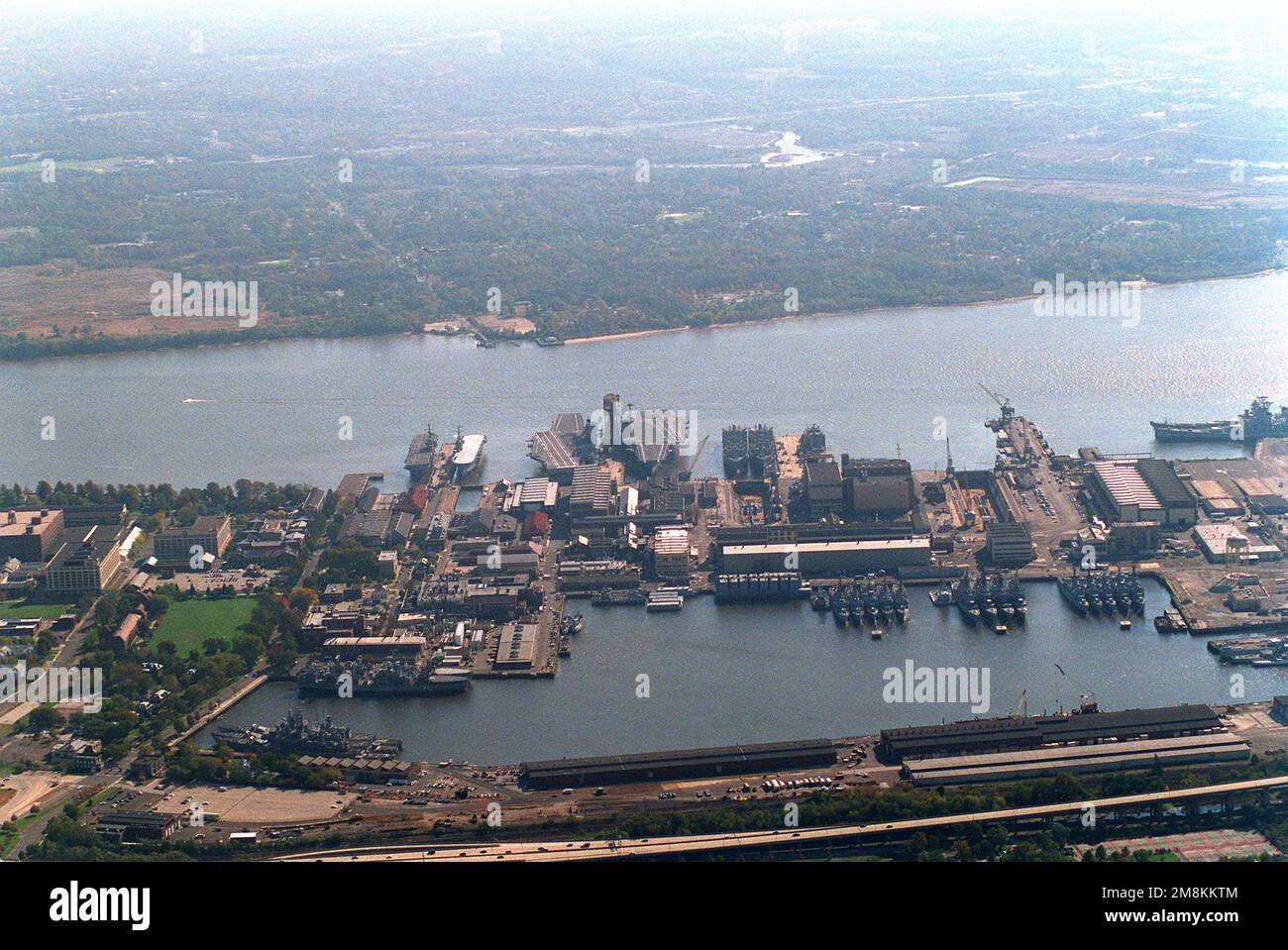 Une vue aérienne du chantier naval de Philadelphie, en regardant vers le sud, montrant de nombreux navires amarrés dans l'installation de maintenance de navires intermédiaires de la Marine. Le chantier naval a fermé sur 30 septembre 1995, mais le NISMF continuera de stocker les navires déclassés et les navires mis en service, les navires mis en service ici : USS IOWA (BB-61) et WISCONSIN (BB-64); le croiseur LOURD DES MOINES (CA-134); les porte-avions FORESTAT (CV-59) et SARATOGA (CV-60); deux CGS; Deux PDD; et de nombreux destroyers, destroyers de missiles guidés et frégates. Base: Philadelphie État: Pennsylvanie (PA) pays: Unis Banque D'Images