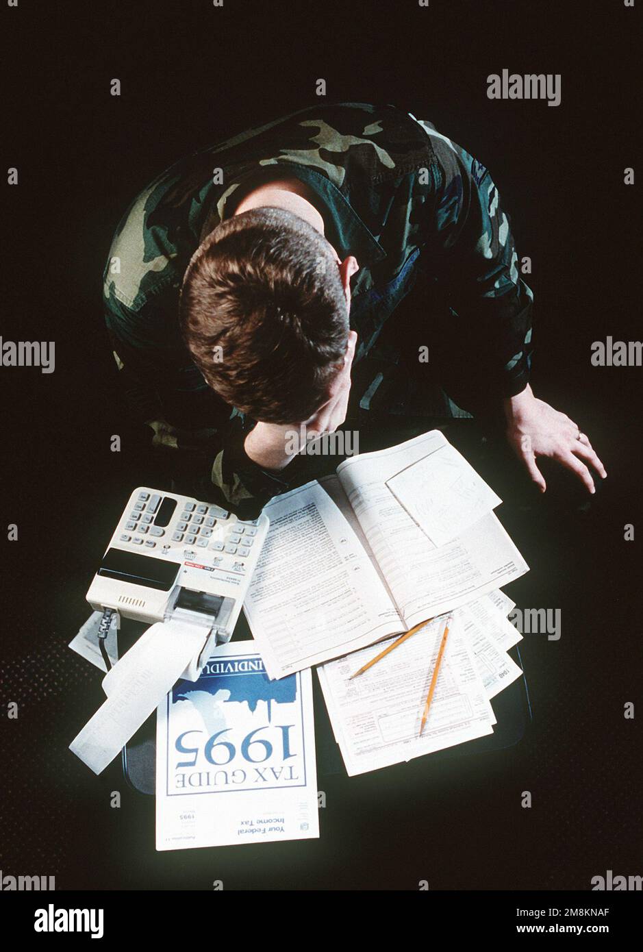 Photographe militaire de l'année gagnant 1996 titre: Les difficultés fiscales Catégorie: Illustration lieu: Troisième place brève Description: Un soldat tombe la tête dans sa main sur son bureau plein de formulaires fiscaux. Date exacte prise de vue inconnue. Pays : inconnu Banque D'Images