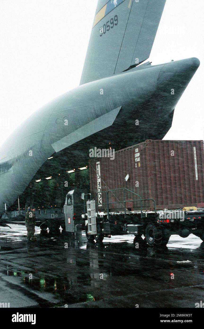 Des spécialistes du transport aérien du 615th Aerial Port Squadron, base aérienne de Travis, en Californie, déchargent sous la pluie un C-17 Globemaster III de la base aérienne de Charleston, en Caroline du Sud. Base: Taszar Air base pays: Hongrie (HUN) Banque D'Images