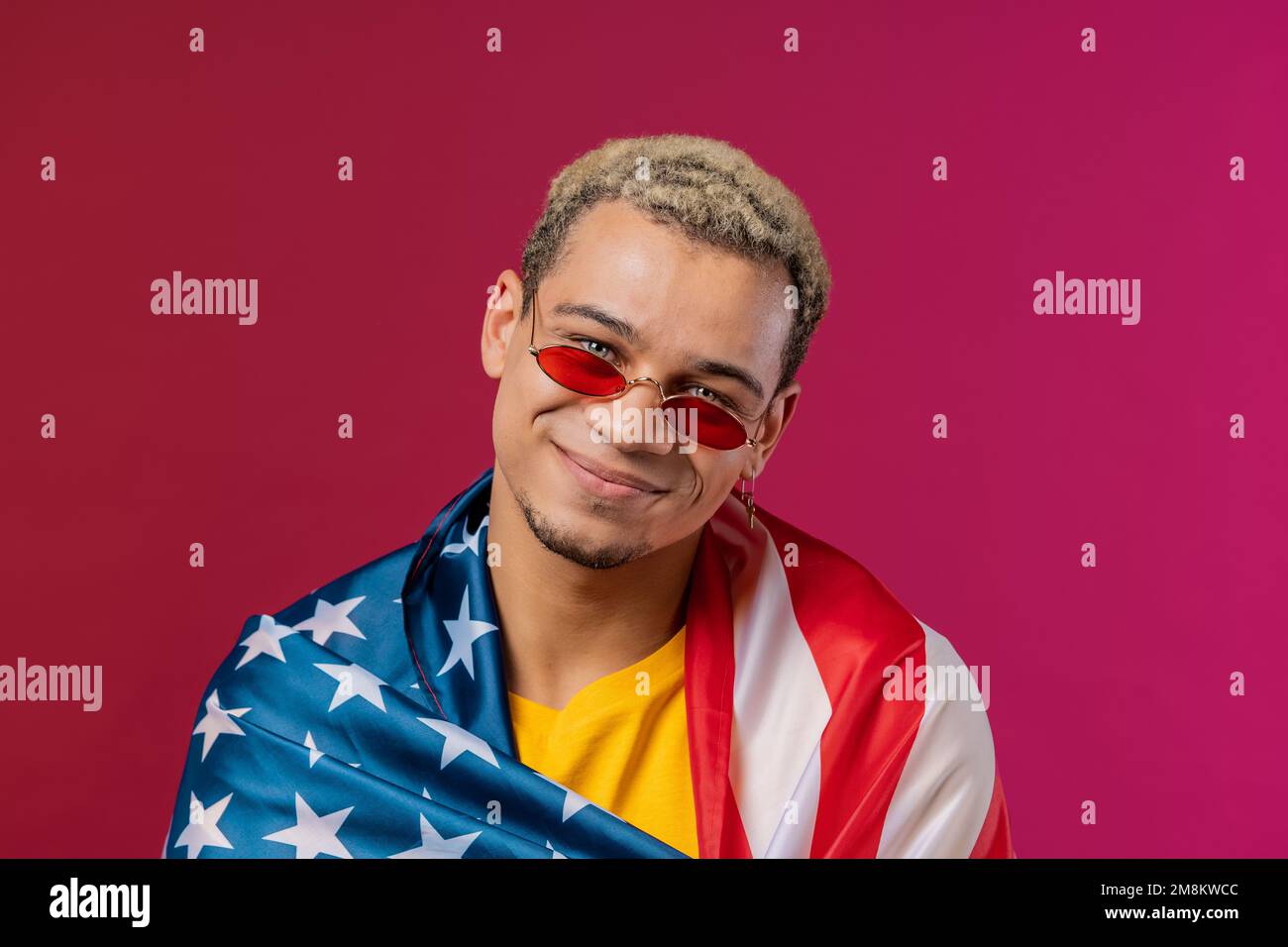 Homme heureux avec drapeau national des États-Unis sur fond rouge. Patriote américain, 4th juillet - célébration de l'indépendance, élection, Amérique, travail. BANNIÈRE AMÉRICAINE. Banque D'Images