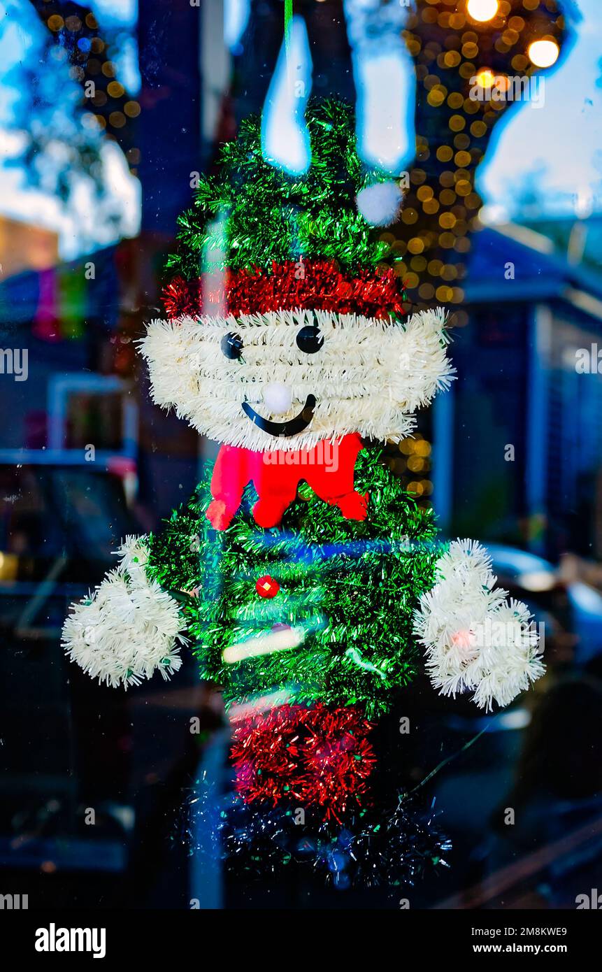 Un ornement de Noël millésime de bonhomme de neige des années 60 fait de tinsel est suspendu dans une fenêtre sur Washington Avenue, le 28 décembre 2022, à Ocean Springs, Mississippi. Banque D'Images