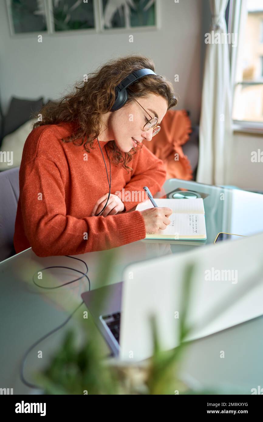 Jeune femme étudiante à l'université portant un casque à l'aide de l'apprentissage en ligne d'un ordinateur portable. Banque D'Images