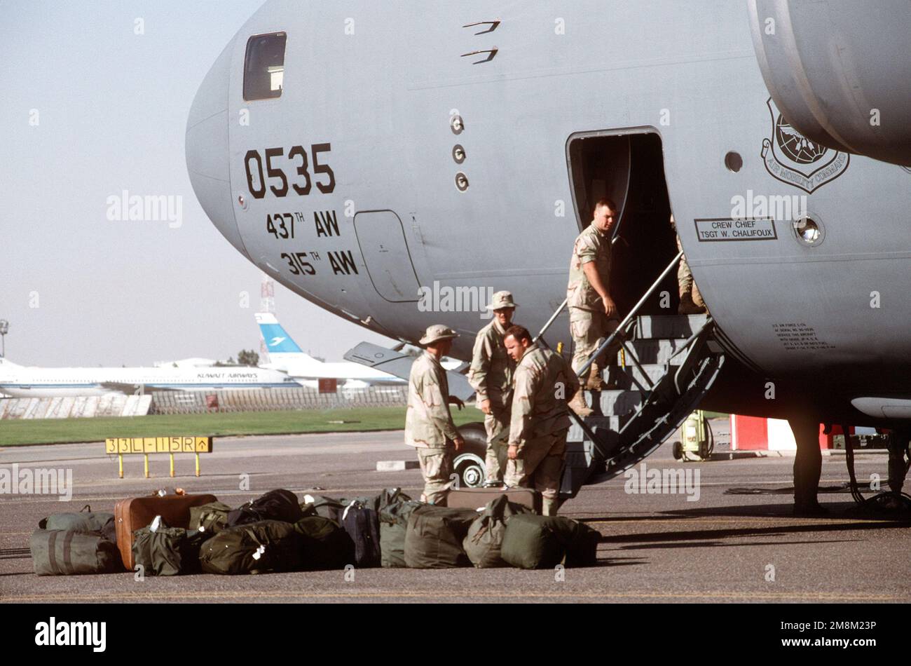 À 0730 heures, les équipages déchargent les bagages de l'avant d'un C-17 Globemaster III Huit C-17s ont participé à l'opération qui marque la première mission d'exercice à grande échelle pour le plus récent aéronef du Commandement de la mobilité aérienne. Ils ont terminé une évaluation difficile plus tôt dans le mois. Objet opération/série: BASE D'ACTION INTRINSÈQUE: Aéroport international du Koweït pays: Koweït (KWT) Banque D'Images