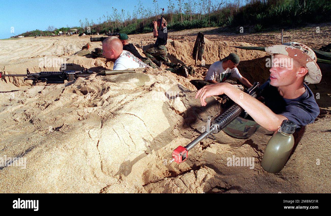 CORPS DES Marines LE caporal Jami Bradshaw (à l'extrême droite) attend avec impatience l'arrivée d'une force d'assaut amphibie composée de Marines, de 11th Marine Expeditionary Unit, Camp Pendleton, Californie, Comme lui et ses collègues Marines jouent le rôle d'une force opposée défendant un comté du tiers-monde pendant RIMPAC 96 qui se déroule à Pacific Missle Range Facility, Barking Sands, Kauai, Hawaii. Bradshaw et ses camarades sont du 3rd Bataillon, 3rd Marines, India Company, situé à la station des Marines de Kaneohe Bay, Oahu, Hawaii. Les Marines ont utilisé des blancs pour simuler un vrai scénario de combat lorsque le Banque D'Images