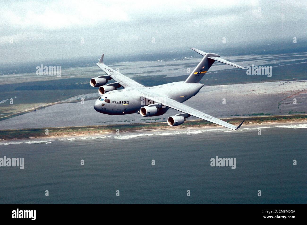 Vue aérienne à gauche d'un C-17 Globemaster III du 17th Airlift Squadron, 437th Air Wing, Charleston Air Force base (Caroline du Sud) qui vole le long de la côte. Base: Charleston État: Caroline du Sud (SC) pays: Etats-Unis d'Amérique (USA) Banque D'Images