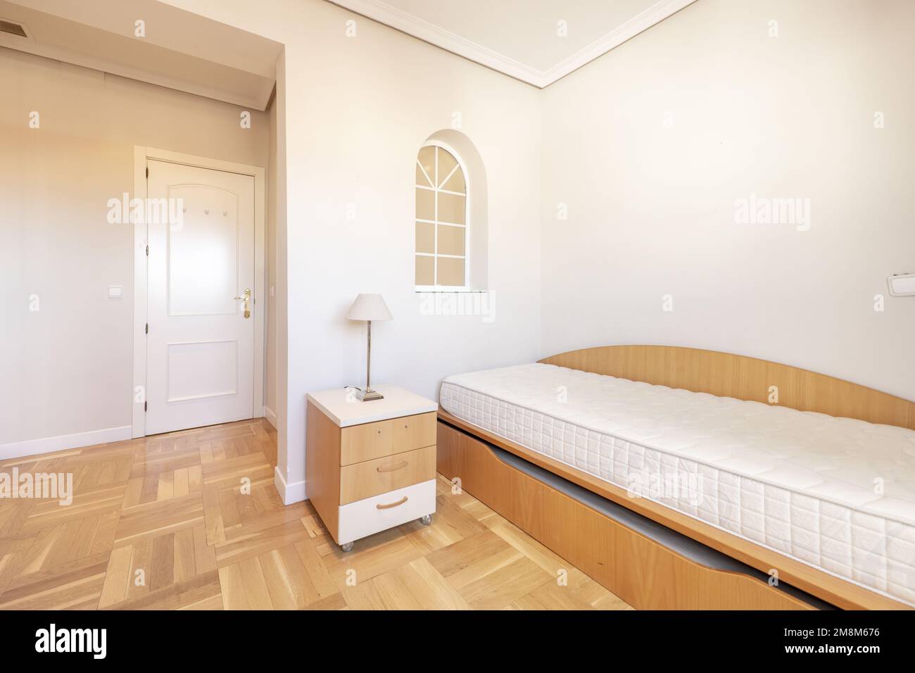 Chambre avec lit gigogne en cerisier sans literie, table de nuit assortie et parquet en chêne Banque D'Images