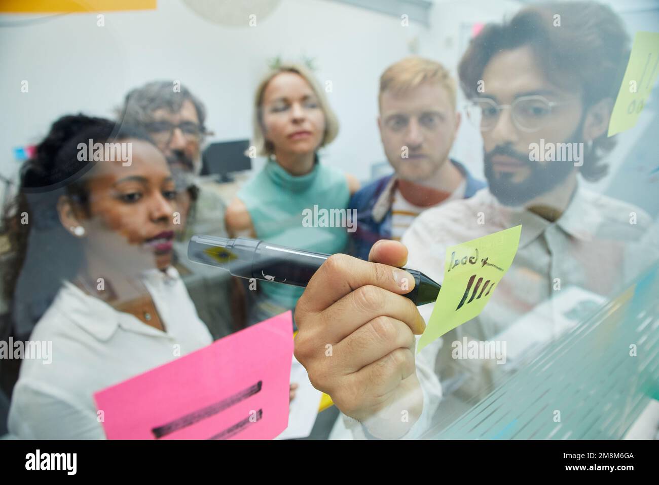Réunion de collègues créatifs au bureau. Remue-méninges de l'équipe de gens d'affaires, rédaction sur note papier. Banque D'Images