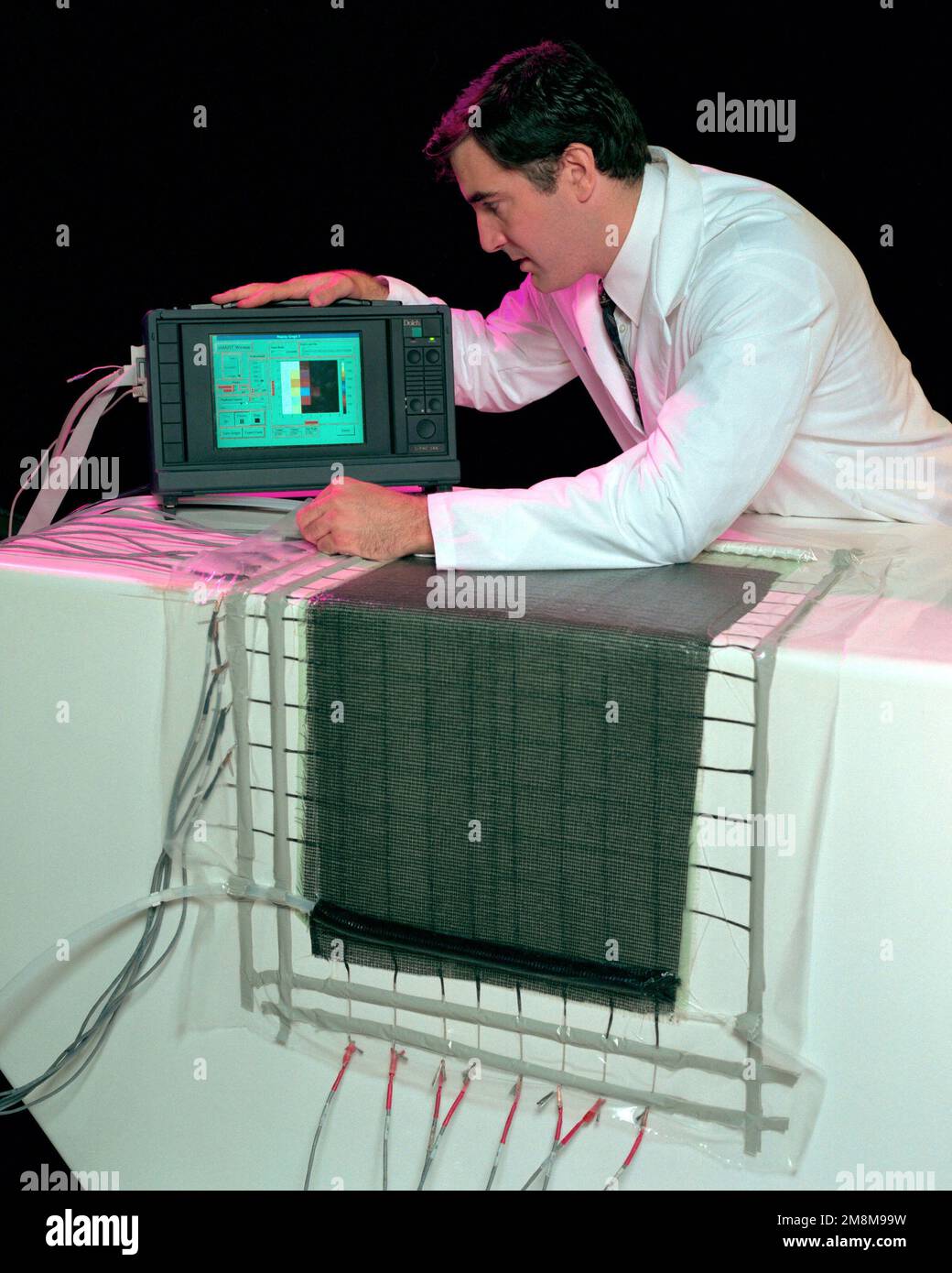 Le Dr Shawn Walsh, ingénieur en matériaux, Laboratoire de recherche de l'armée américaine, Aberdeen Proving Grounds, Adelphi, Maryland, démontre le fonctionnement du système SMARTweave. L'ordinateur affiche l'emplacement du débit de résine pendant le processus. Cette opération a eu lieu au laboratoire de recherche de l'armée américaine, Rodman Materials Building, APG, Adelphi, MD, Sur 17 septembre 1996. Base: Aberdeen Proving Grounds État: Maryland (MD) pays: Etats-Unis d'Amérique (USA) Banque D'Images