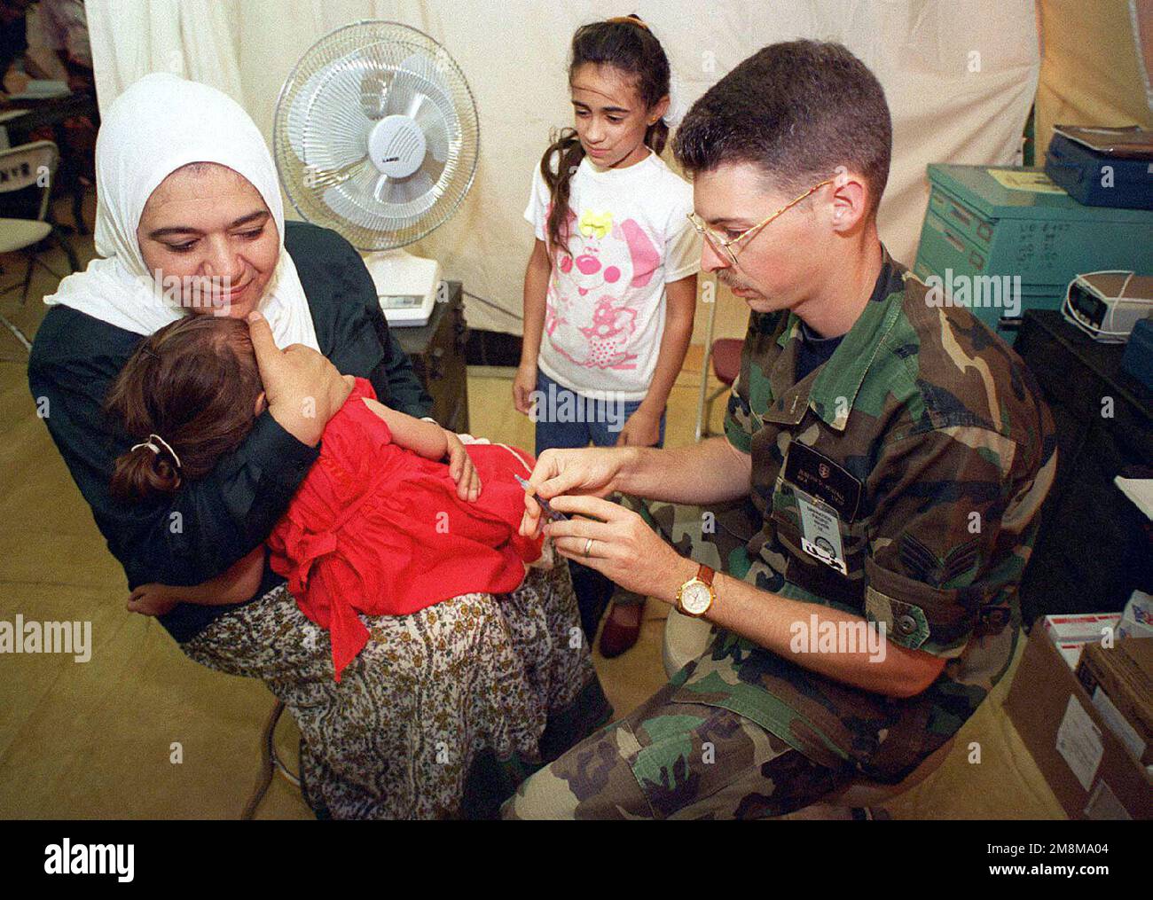 JOSEPH Siddall, 374th Air Transportation Hospital, Yokota, Japon, administre des tirs d'immunisation aux évacués kurdes de la base aérienne d'Andersen, à Guam, au cours DE L'OPÉRATION PACIFIC HAVEN. Pacific Haven, un effort humanitaire conjoint mené par les États-Unis L'armée a transporté par avion plus de 2100 000 réfugiés kurdes du nord de l'Irak. Les réfugiés seront logés temporairement à l'AFB d'Andersen, à Guam, pendant qu'ils passent par le processus d'immigration pour la résidence aux États-Unis. US Airforce Senior Airman (SR) Joseph Siddall, 374th Air Transportation Hospital, Yokota, Japon, administrateur Banque D'Images