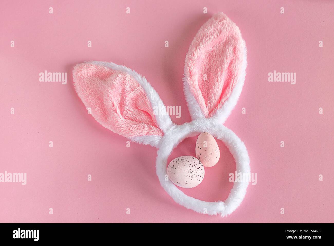 Arrière-plan de Pâques. Oreilles de lapin de Pâques roses sur fond rose. Œufs de Pâques. Pâques. copier l'espace Banque D'Images