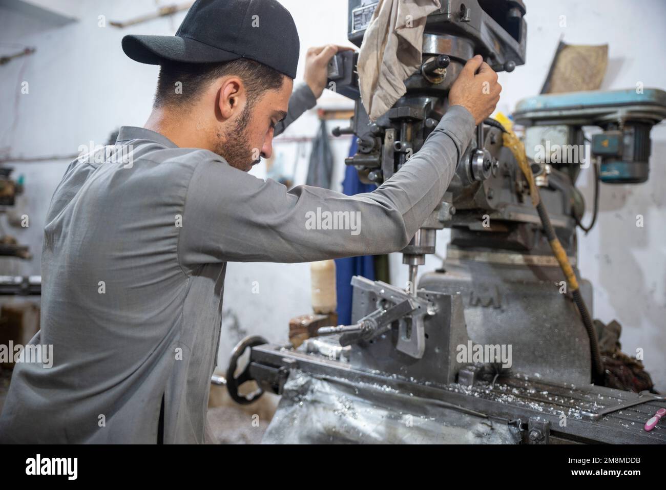 Armurier travaillant sur un revolver dans une usine d'armes, Peshawar, Pakistan Banque D'Images