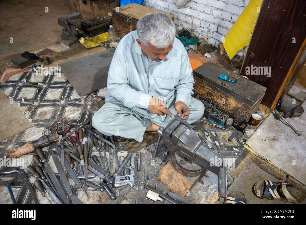 Un armurier produisant des revolvers dans une usine d'armement, Peshawar, Pakistan Banque D'Images