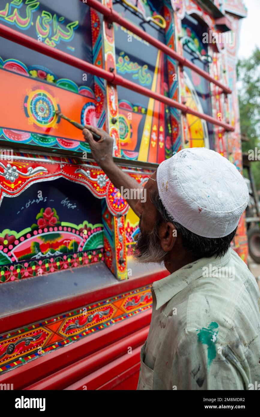 Ouvrier réparant la décoration d'un camion peint, Peshawar, Pakistan Banque D'Images