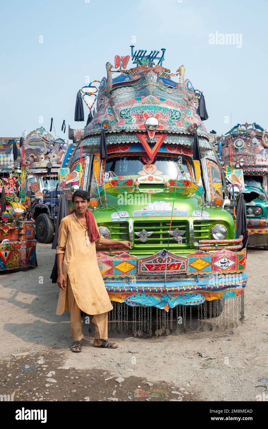 Chauffeur de bus devant son bus peint en couleurs, Peshawar, Pakistan Banque D'Images