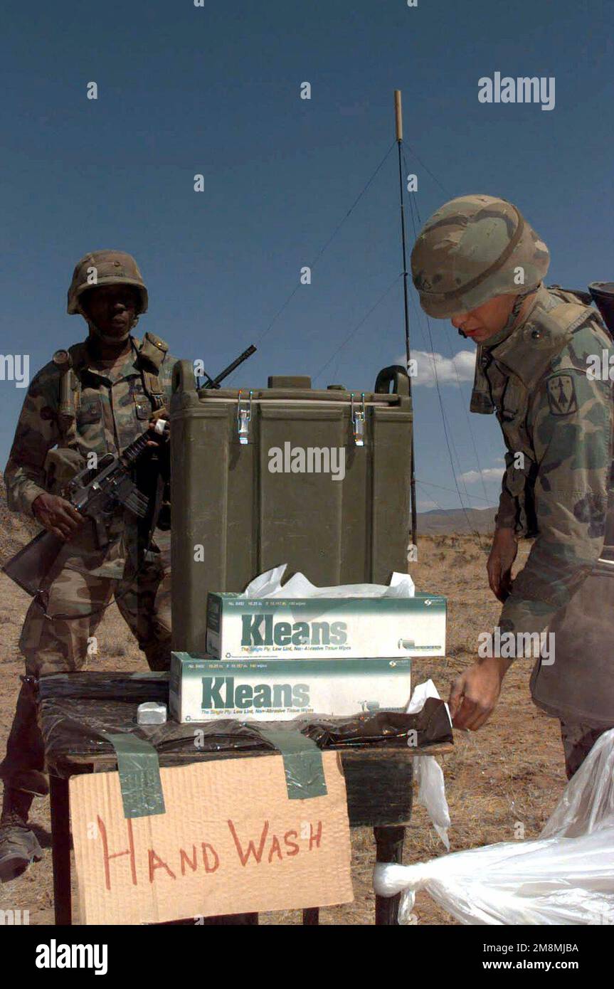 SPC Cote, 31st Armée de défense aérienne, quartier général et batterie de quartier général (HHB), fort Bliss, Texas, lave toute contamination de ses mains avant d'entrer dans la remorque de cuisine mobile. Le processus de décontamination est observé par PFC June (contexte) lors de leur participation à l'exercice d'opérations aériennes tactiques multinationales, le plus important service conjoint au monde. Objet opération/série: ROVING SANDS '97 base: McGregor Range État: Nouveau Mexique (NM) pays: États-Unis d'Amérique (USA) Banque D'Images