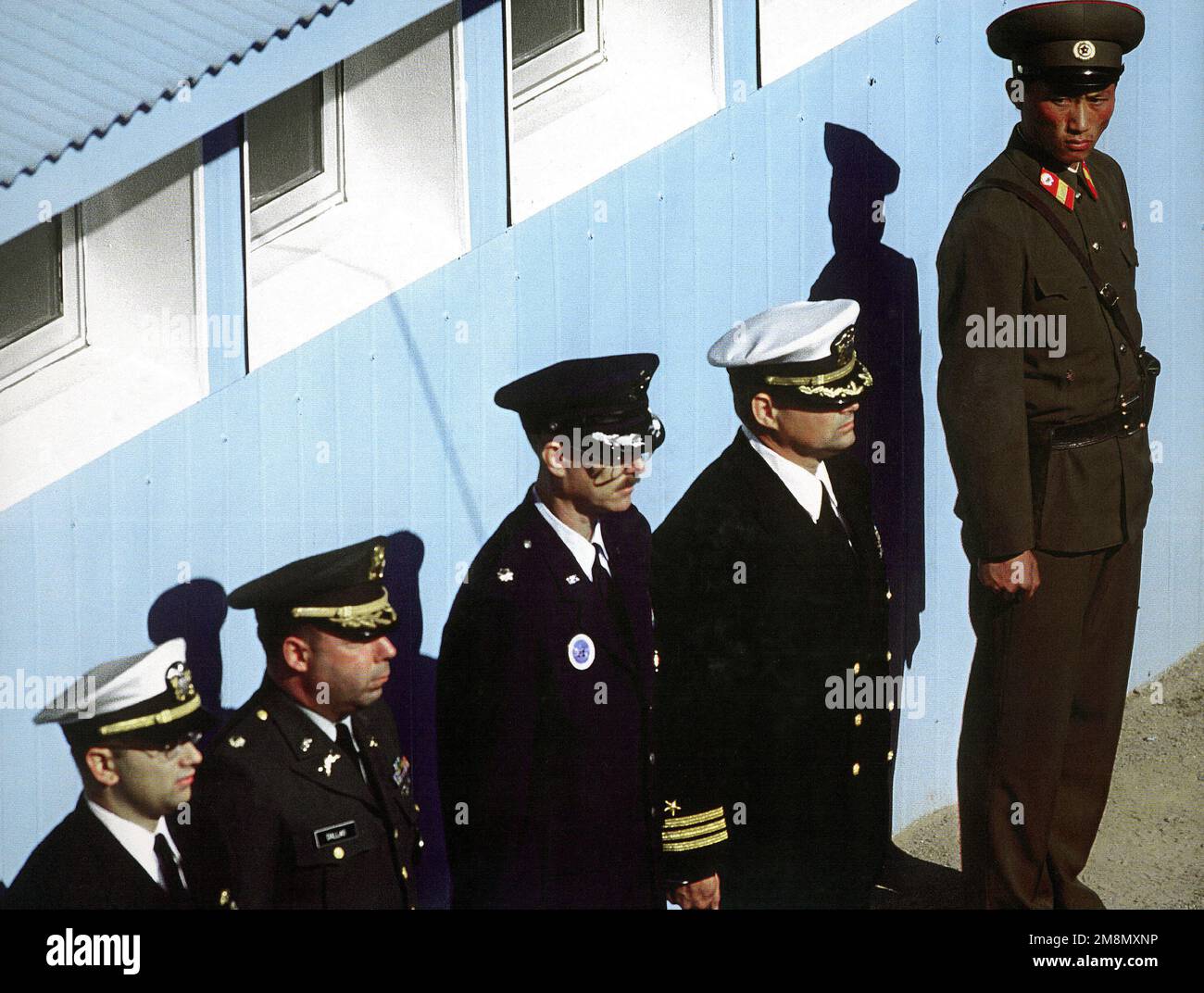 Photographe militaire de l'année vainqueur 1998Title: Les dimensionner UpCategory: NewsPlace: Deuxième place nouvelles/troisième place PortfolioA soldat coréen de l'Armée populaire de Coréen se délasse devant des représentants de l'UNC lors d'une cérémonie de rapatriement dans la zone de sécurité commune de Panmunjom, République de Corée (ROK) le 6 novembre 1998. Le rapatriement des vestiges de la guerre de Corée est le résultat d'une opération conjointe de récupération entre les États-Unis et la République populaire démocratique de Corée en Corée du Nord pour localiser et renvoyer les membres du service américain à leur patrie par l'intermédiaire de Panmunjom. Vingt-sept membres du service ont été retournés depuis l'opér. De récupération conjointe Banque D'Images