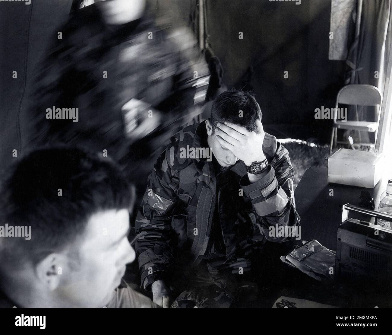 Photographe militaire de l'année gagnant 1998 titre : combien de temps ? Catégorie: Nouvelles lieu: Troisième place NewsAfter de nombreux 'Alarm Red' et 'mopp 4', un membre épuisé de l'aile 319th Air ravitailling prend un moment pour se recueillir tandis que l'activité continue autour de lui. La participation des aviateurs de la base aérienne de Grand Forks, N.D., on 20 mai 1998, à cet exercice de préparation opérationnelle locale les préparera à une inspection de préparation opérationnelle à venir à l'été 1999. Pays : inconnu Banque D'Images