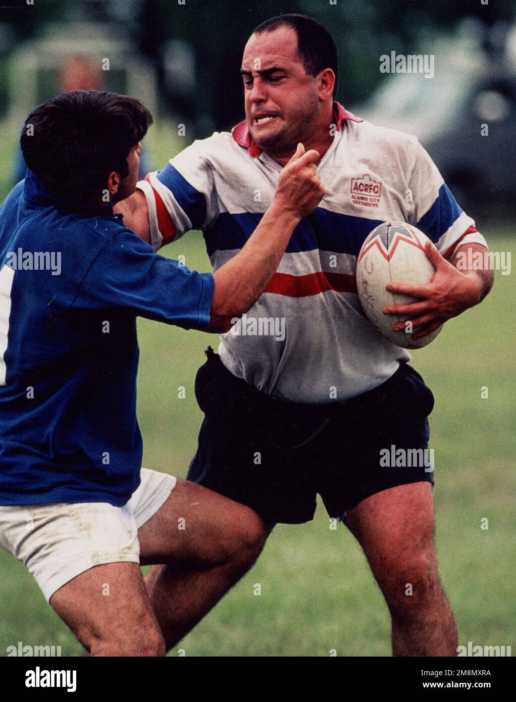 Prix du photographe militaire de l'année 1998 titre: 'Go Away!'Catégorie: SportsPlace: Troisième place Sports/deuxième place Portfolio et Prix de l'Association nationale des photographes de presse. Un joueur de rugby des Alamo City Defenders défend vigoureusement le ballon lors de la « bataille de l'Alamo » tournoi de rugby à Brooks AFB, Park, San Antonio, Texas. Pays : inconnu Banque D'Images
