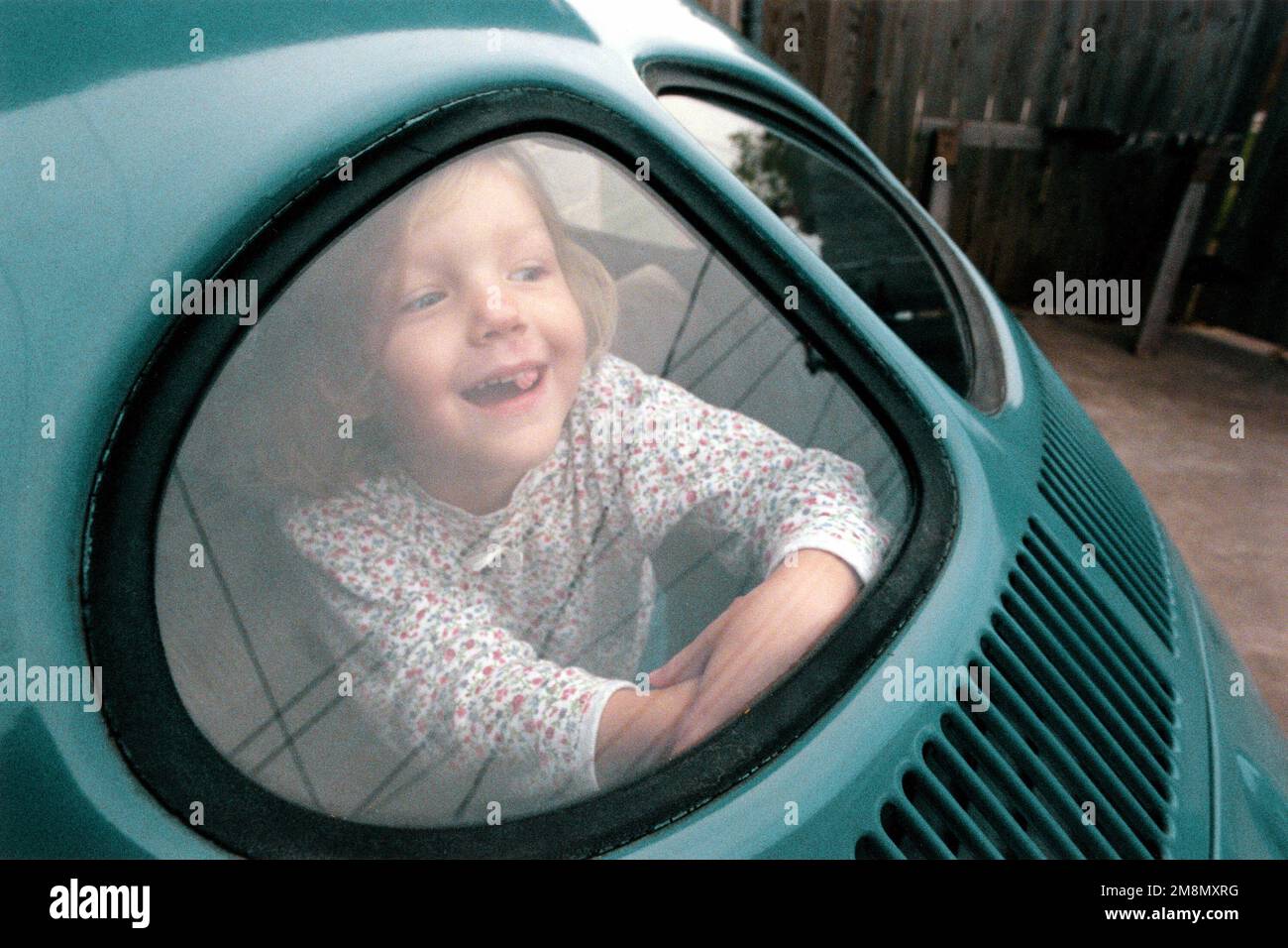 Photographe militaire de l'année vainqueur 1998 titre: Samantha Catégorie: Portrait lieu: Troisième place PortraitSamantha Dorman, 4 ans, joue dans le dos de Volkswagen de son père. Pays : inconnu Banque D'Images