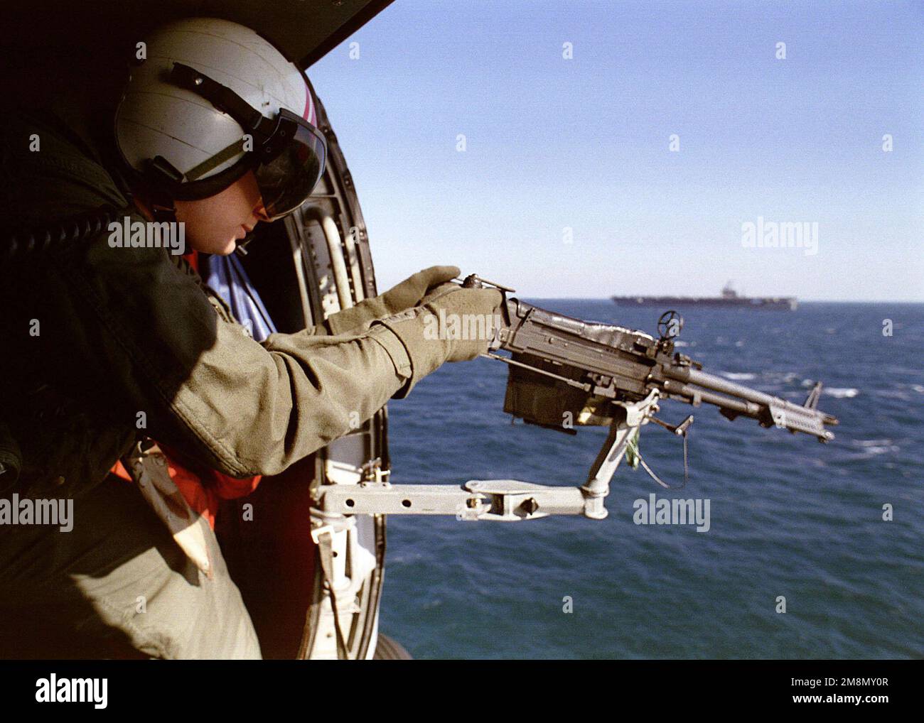 Aviation anti-sous-marin Warfare Operator 1st Class James Stephens a une mitrailleuse de calibre .50 lors d'une mission d'entraînement à bord d'un hélicoptère anti-sous-marin SH-60 Sea Hawk lancé à partir du porte-avions USS NIMITZ (CVN 68). Nimitz opère dans le golfe Persique à l'appui de l'opération Southern Watch. Objet opération/série : BASE DE VEILLE DU SUD : USS Nimitz (CVN 68) Banque D'Images