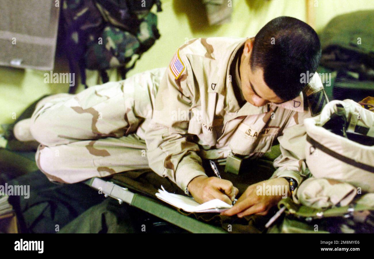PFC Julian Navarro prend une pause pour écrire une lettre à la maison. Navarro et environ 1 500 membres du service américain participent à UNE ACTION INTRINSÈQUE. L'exercice fait intervenir les forces armées américaines et koweïtiennes dans un effort visant à renforcer les relations et à renforcer les capacités de déploiement des forces américaines. (Image dupliquée, voir aussi DD-SD-01-05179). Objet opération/série: ACTION INTRINSÈQUE base: Kabal pays: Koweït (KWT) Banque D'Images