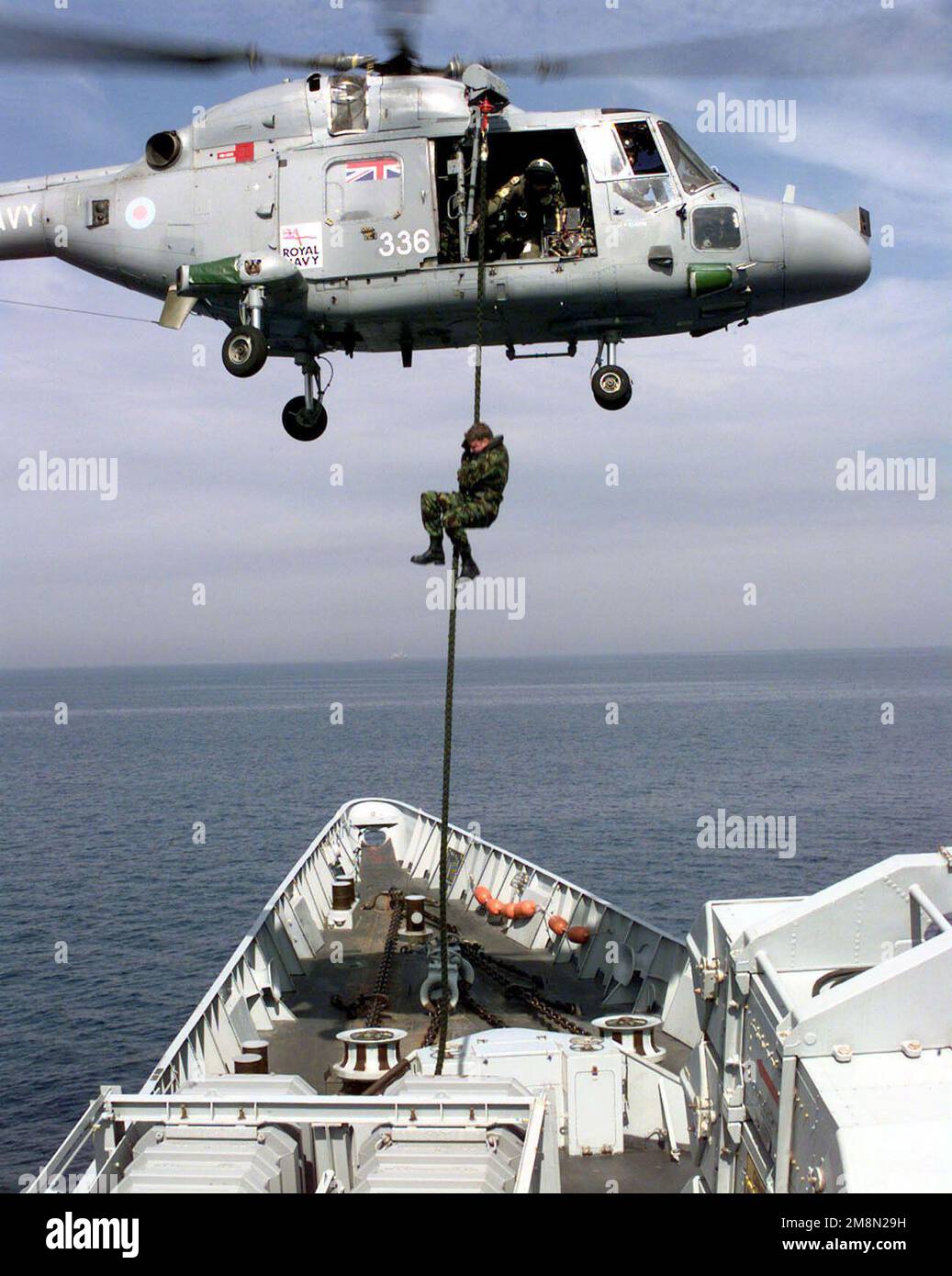 Le lieutenant de la Marine royale britannique, Adrian Bratt, officier d'embarquement pour la frégate de classe Broadsape, HMS COVENTRY (F 98), cordes rapides d'un hélicoptère Lynx HMA 8 de la Marine royale jusqu'au pont pendant les exercices d'embarquement dans le golfe Persique. Le navire britannique se trouve dans le golfe pour soutenir la construction de l'Asie du Sud-Ouest. Base : HMS Conventry (F 98) Banque D'Images