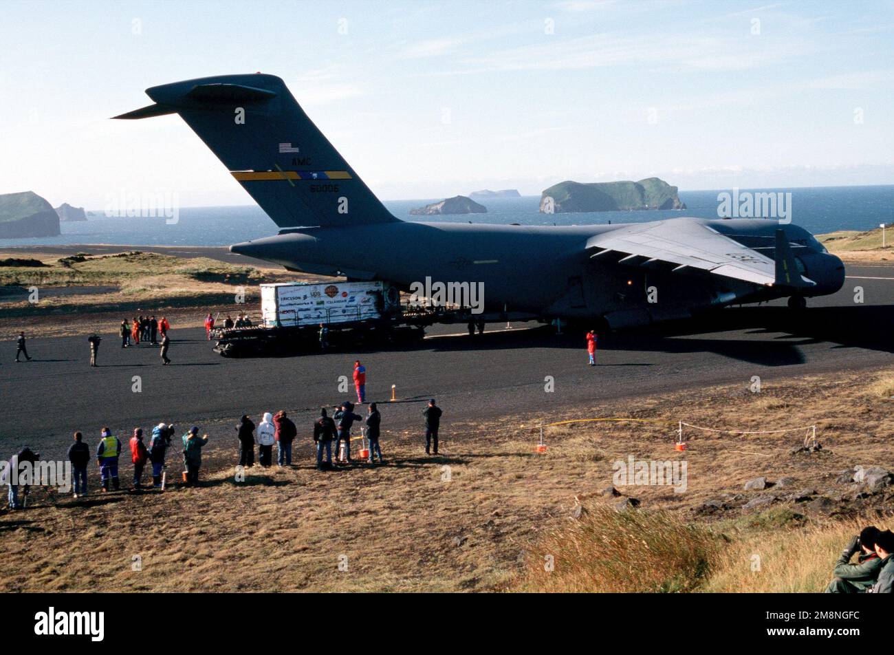 Vue arrière du côté droit et long cliché d'un Globemaster III C-17 de l'USAF situé au bout d'une piste à Westman Island, en Islande. Keiko l'épaulard et son char sont déchargés de l'avion et sur un Tunner de 60K à Vestmannaeyjar, en Islande, après un vol de neuf heures au départ de Newport, en Oregon. Base: Vestmannaeyjar pays: Islande (ISL) Banque D'Images
