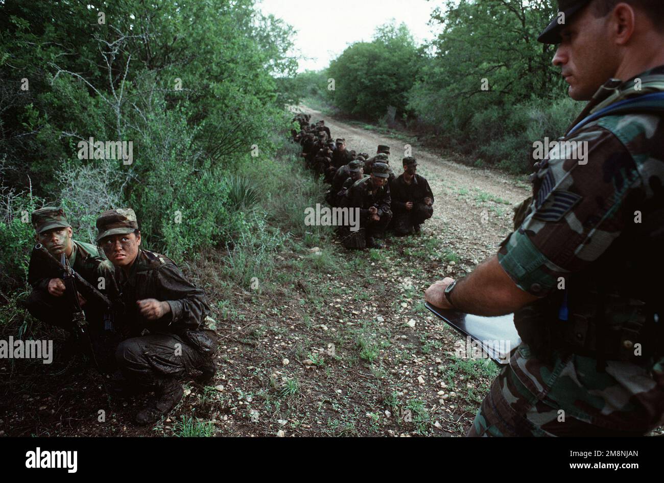 US Air Force AIRMAN Basic AIRMAN Basic beau Woods et Wilma Cabading se tourner vers l'instructeur d'entraînement, Le sergent technique Bryan Blue a reçu des conseils sur la façon de conduire son vol dans les zones dangereuses qui sont vulnérables à une embuscade dans un nouveau camp d'entraînement nommé « Corpion's Nest », l'une des façons dont les instructeurs ramènent le « dur » dans le « camp de chaussures » de la base aérienne de Lackland, au Texas. Base: Lackland Air Force base État: Texas (TX) pays: Etats-Unis d'Amérique (USA) Banque D'Images