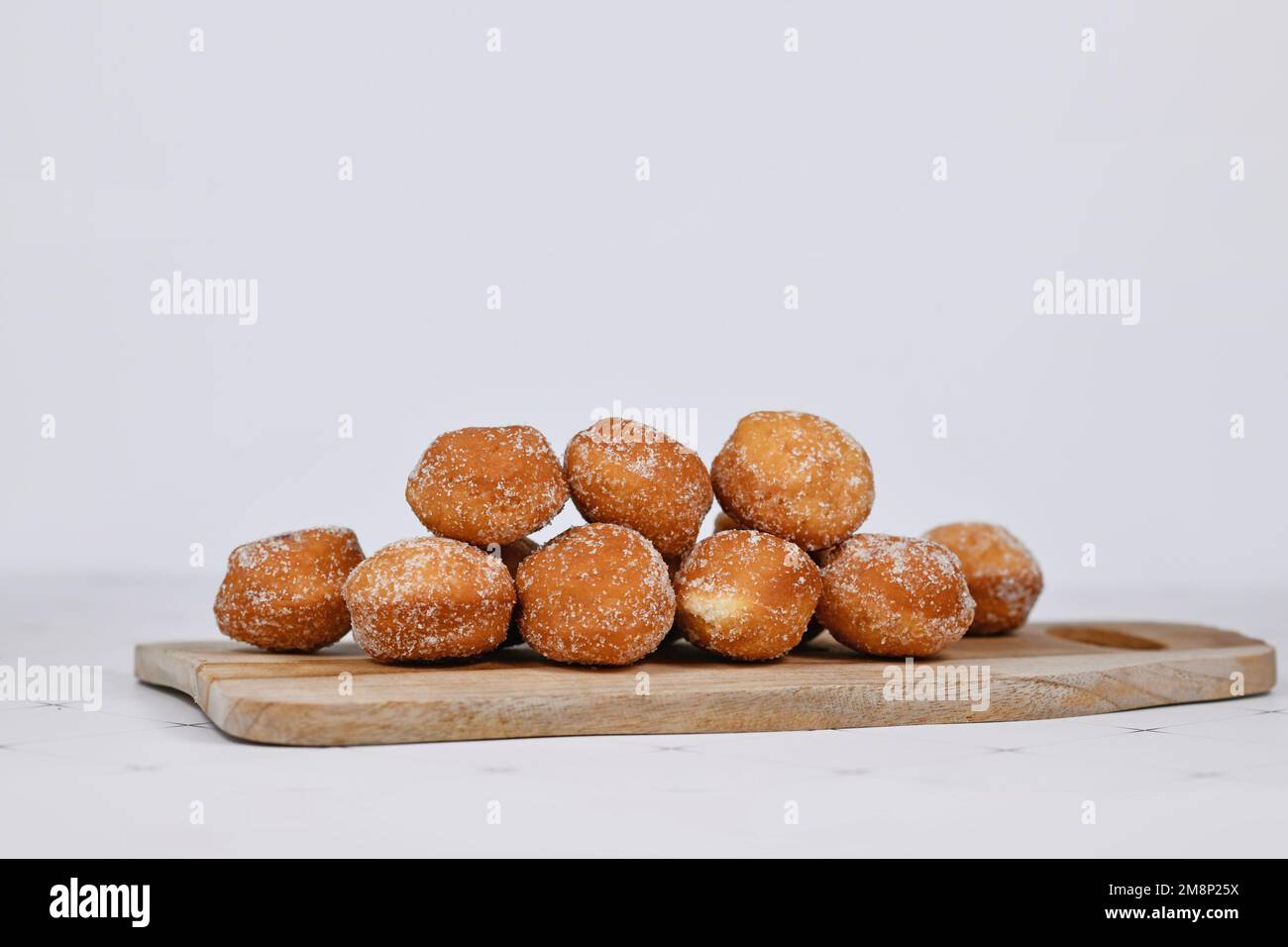 Le traditionnel allemand 'Berliner Pfannkuchen', un donut sans trou rempli de confiture sur une planche à découper en bois Banque D'Images