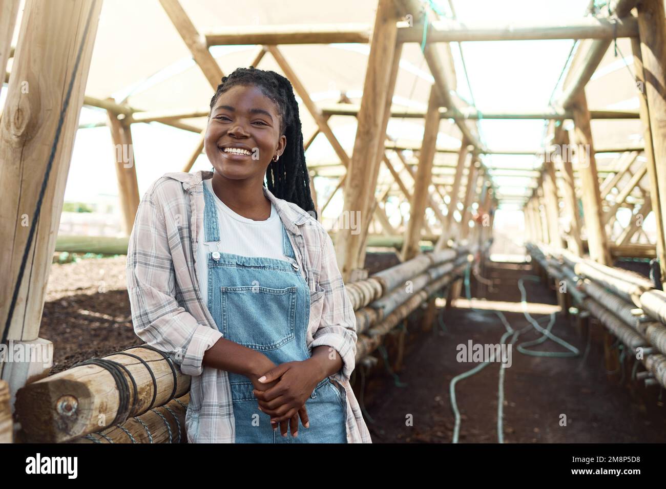 Jeune agriculteur debout sur une ferme. Portrait d'un fermier heureux debout dans une serre. Jeune femme travaillant sur une ferme durable. Employé agricole travaillant Banque D'Images
